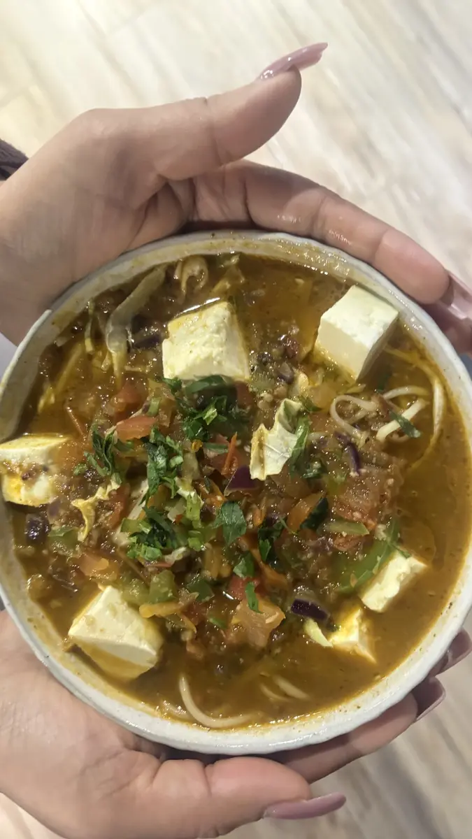Paneer and noodle bowl with vegetables at Aura Indian Cuisine