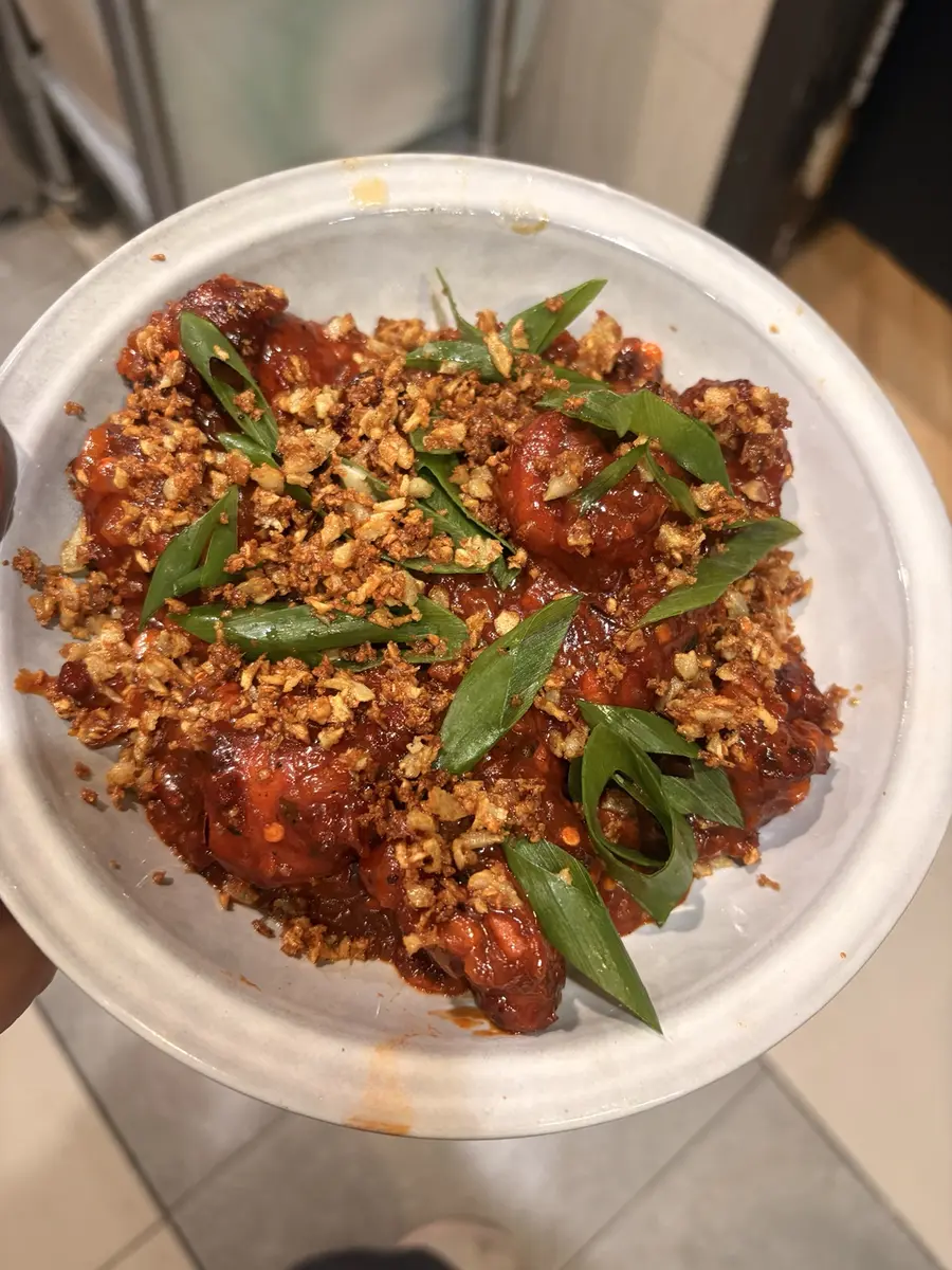 Spicy Indo-Chinese dish finished with crispy garlic and spring onion at Aura