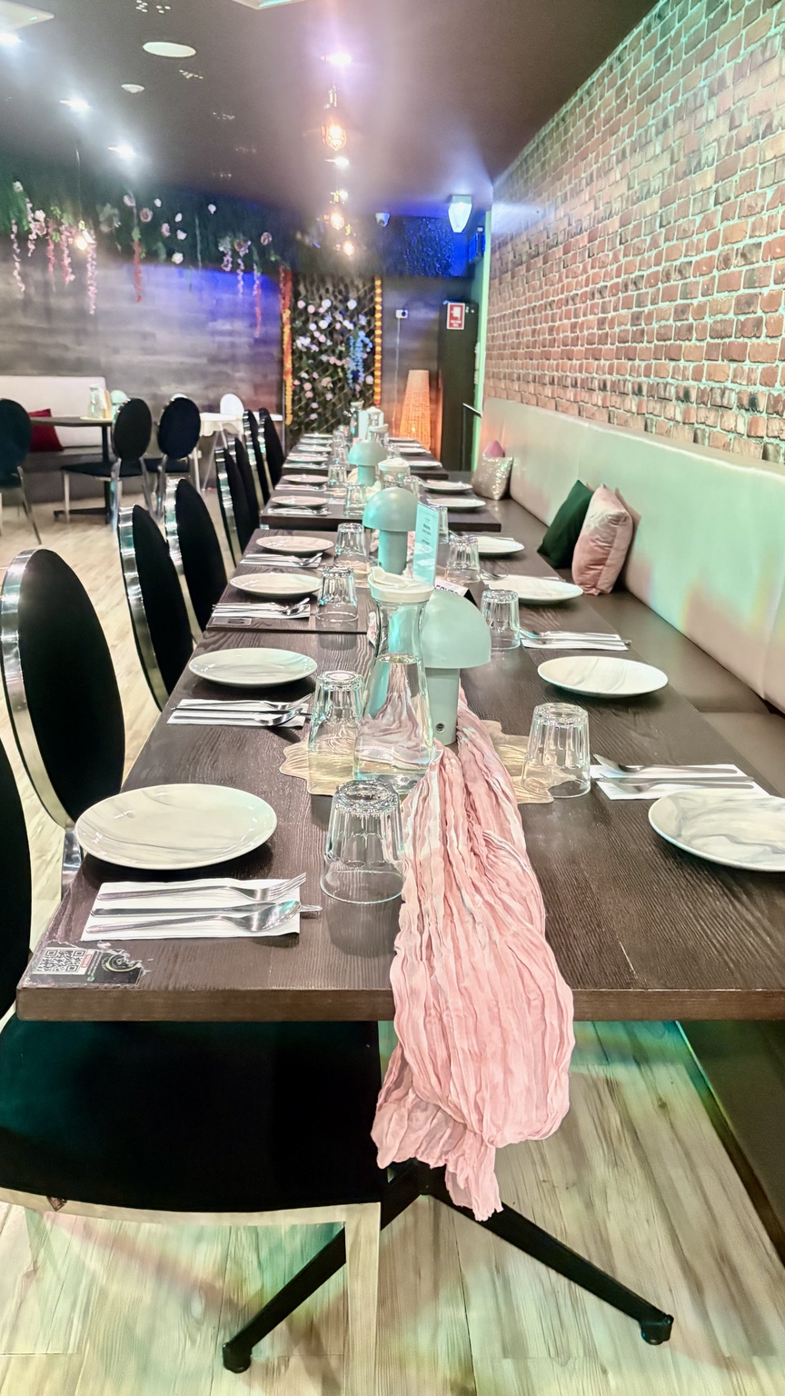A long celebration table set for guests inside Aura Indian Cuisine